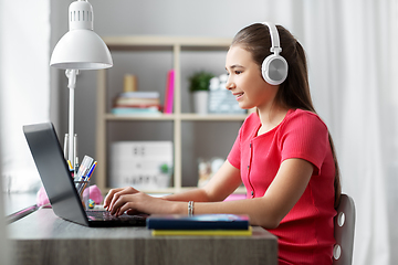 Image showing girl in headphones with laptop computer at home