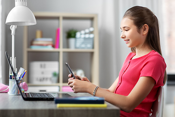 Image showing girl with smartphone distracting from homework