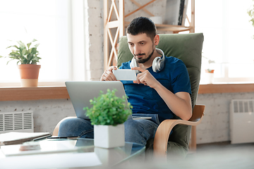 Image showing Young focused man studying at home during online courses or free information by hisself