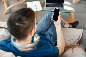 Image showing Young focused man studying at home during online courses or free information by hisself