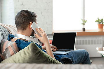 Image showing Young focused man studying at home during online courses or free information by hisself