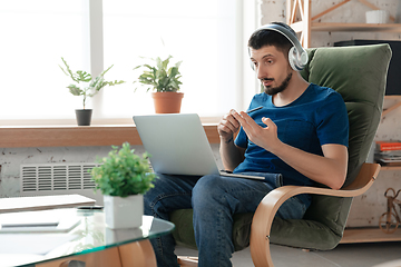 Image showing Young focused man studying at home during online courses or free information by hisself