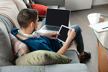 Image showing Young focused man studying at home during online courses or free information by hisself