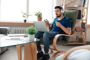 Image showing Young focused man studying at home during online courses or free information by hisself