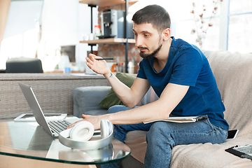 Image showing Young focused man studying at home during online courses or free information by hisself