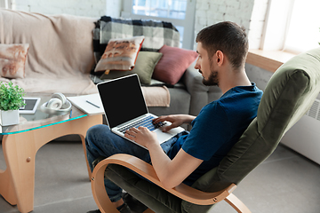 Image showing Young focused man studying at home during online courses or free information by hisself