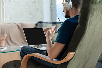 Image showing Young focused man studying at home during online courses or free information by hisself