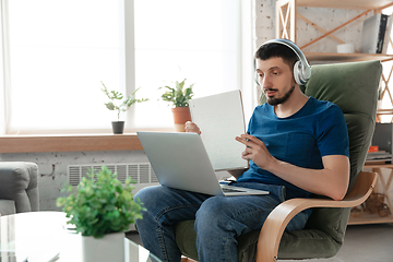 Image showing Young focused man studying at home during online courses or free information by hisself