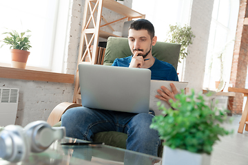 Image showing Young focused man studying at home during online courses or free information by hisself