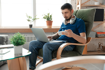 Image showing Young focused man studying at home during online courses or free information by hisself