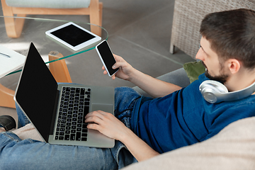 Image showing Young focused man studying at home during online courses or free information by hisself