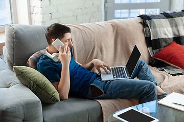 Image showing Young focused man studying at home during online courses or free information by hisself