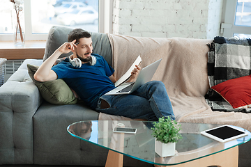 Image showing Young focused man studying at home during online courses or free information by hisself