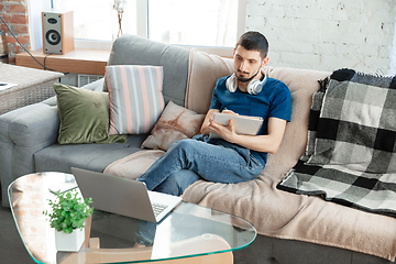 Image showing Young focused man studying at home during online courses or free information by hisself