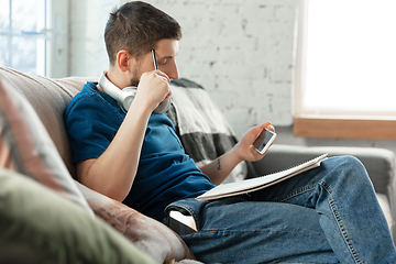 Image showing Young focused man studying at home during online courses or free information by hisself