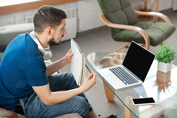 Image showing Young focused man studying at home during online courses or free information by hisself