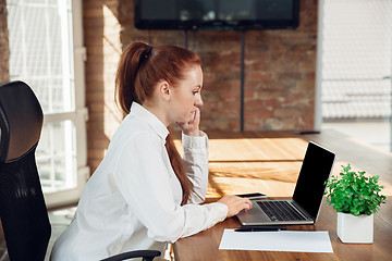 Image showing Caucasian young woman in business attire working in office