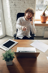Image showing Caucasian young man in business attire working in office, job, online studying