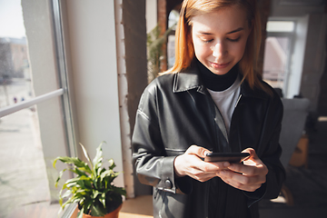 Image showing Young woman using gadgets to watch cinema, photos, online courses, taking selfie or vlog, online shopping