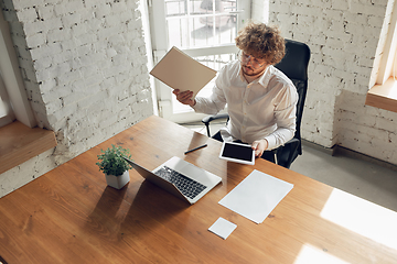 Image showing Caucasian young man in business attire working in office, job, online studying