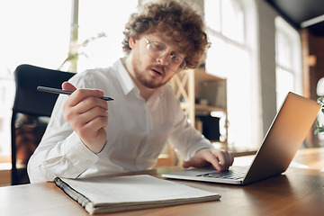 Image showing Caucasian young man in business attire working in office, job, online studying