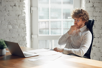 Image showing Caucasian young man in business attire working in office, job, online studying