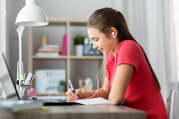 Image showing student girl in earphones learning at home