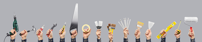 Image showing builder's hands holding different working tools