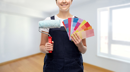 Image showing close up of painter with roller and color charts