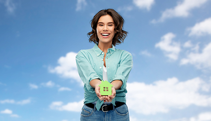 Image showing smiling young woman holding green house