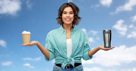 Image showing woman comparing thermo cup and paper coffee cup