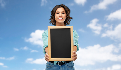 Image showing portrait of smiling woman showing black chalkboard