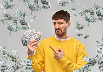 Image showing displeased man in sweatshirt with dollar money