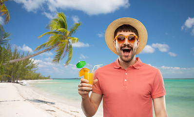 Image showing happy man in straw hat with juice on beach