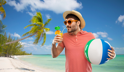 Image showing happy man in straw hat with juice on beach