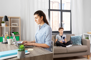 Image showing working mother and son playing video game at home