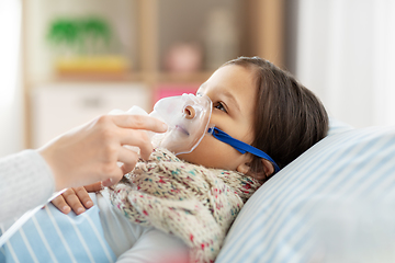 Image showing mother and sick daughter with oxygen mask in bed