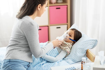 Image showing mother and sick daughter with oxygen mask in bed