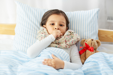 Image showing sick coughing girl lying in bed at home