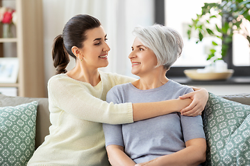 Image showing senior mother with adult daughter hugging at home