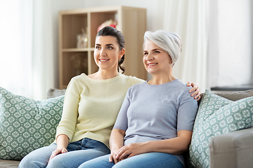 Image showing senior mother with adult daughter hugging at home