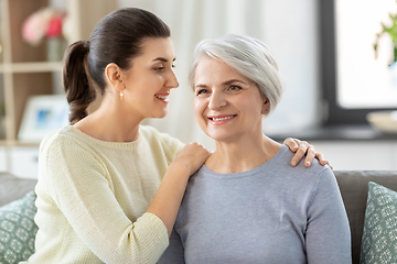 Image showing senior mother with adult daughter hugging at home