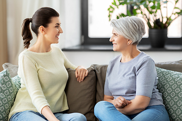 Image showing senior mother with adult daughter talking at home