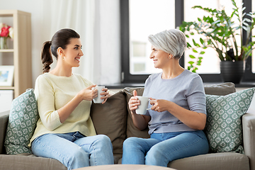 Image showing senior mother and adult daughter drinking coffee