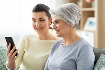 Image showing daughter and senior mother with smartphone at home