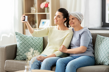 Image showing senior mother with daughter taking selfie at home