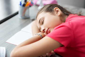 Image showing tired student girl sleeping on table at home