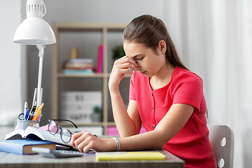 Image showing tired teenage student girl with glasses at home