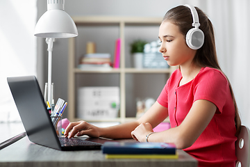 Image showing girl in headphones with laptop computer at home