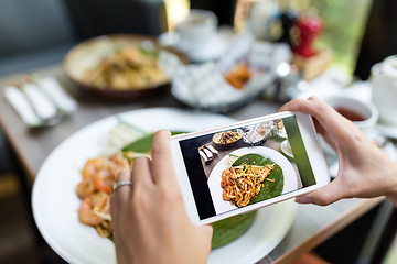 Image showing Woman taking photo on food